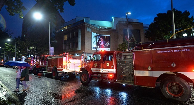 Colombian firefighters stand outside a shopping center following an explosion inside the building which -according to authorities- left one dead and eleven injured, in Bogota, Colombia, on June 17, 2017. (AFP-Yonhap)