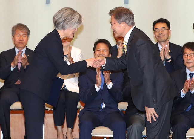 President Moon Jae-in (right) shakes hands with Foreign Minister Kang Kyung-hwa after she was formally appointed at Cheong Wa Dae in Seoul on Sunday. (Yonhap)