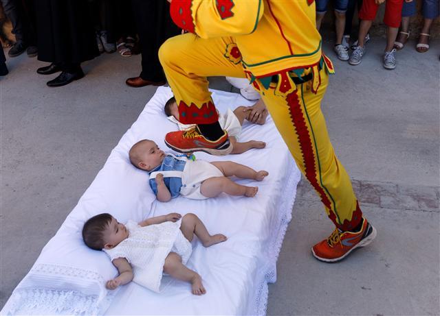 <YONHAP PHOTO-0596> A man dressed up as the devil jumps over babies lying on a mattress in the street during 'El Colacho', the 'baby jumping festival' in the village of Castrillo de Murcia, near Burgos on June 18, 2017. Baby jumping (El Colacho) is a traditional Spanish practice dating back to 1620 that takes place annually to celebrate the Catholic feast of Corpus Christi. During the act - known as El Salto del Colacho (the devil's jump) or simply El Colacho - men dressed as the Devil jump over babies born in the last twelve months of the year who lie on mattresses in the street. / AFP PHOTO / CESAR MANSO/2017-06-19 04:27:28/ <저작권자 ⓒ 1980-2017 ㈜연합뉴스. 무단 전재 재배포 금지.>
