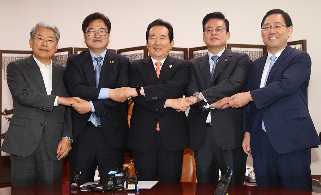 National Assembly Speaker Chung Sye-kyun (center) and the floor leaders of the major parties hold hands together before their regular meeting at the legislature in Seoul on June 19, 2017. (Yonhap)