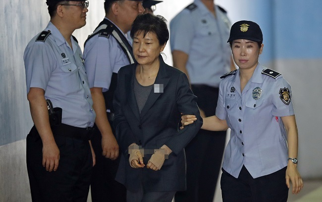 Park Geun-hye is escorted into the Seoul Southern District Court for a hearing Monday. (Yonhap)