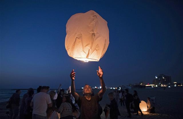 <YONHAP PHOTO-0919> epa06037978 Israeli peace activists gather to launch some 150 paper lanterns into the air near the border with the Gaza Strip in Ashkelon, Israel, 19 June 2017. The paper lanterns were released into the air in solidarity with Gaza residents that are continuously facing power cuts. Israel on 11 June agreed to a request by the Palestinian Authority and reduce electricity in Gaza by another 40 percent, bringing it down to about three hours of electricity being available. EPA/ABIR SULTAN/2017-06-20 05:43:57/ <저작권자 ⓒ 1980-2017 ㈜연합뉴스. 무단 전재 재배포 금지.>