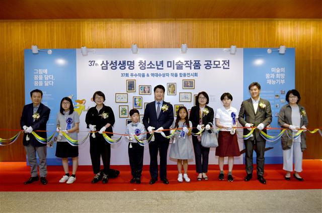 청소년 미술작품 공모전 시상식에서 김창수 사장(왼쪽 다섯번째)과 수상자, 후원미대학장 등이 합동전시회 기념 테이프를 커팅 하고 있다.