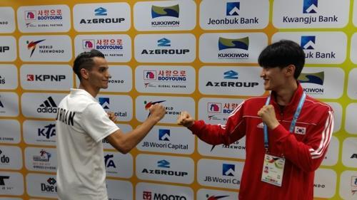 Ahmad Abughaush of Jordan (left) and Lee Dae-hoon of South Korea pose for photos following a press conference ahead of the World Taekwondo Federation World Taekwondo Championships at T1 Arena in Taekwondowon in Muju, North Jeolla Province, on June 24, 2017. (Yonhap)