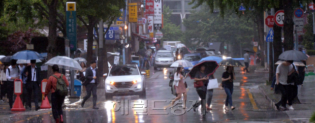 극심한 가뭄에 단비가 내린다. 26일 장마전선은 멀리 남부지방에 머물러 있는 가운데 전국적으로 기압골의 영향으로 국지성 호우가 쏟아지고 있다. 기상청은 소나기성 호우가 가뭄극복에 도움이 되겠지만 지형적 영향으로 전국적으로 편차가 심할것으로 예보했다. 광화문광장 출근길 시민들이 빗속에서 출근하고 있다. <br />정희조 기자/checho@heraldcorp.com  170626