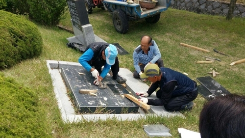 Workers remove a cenotaph for Korean victims of forced labor under Japan's colonial rule at a national cemetery in the city of Cheonan, south of Seoul, in this undated photo released by the cemetery office on June 26, 2017. (Yonhap)