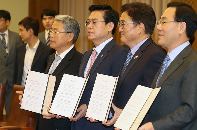 The floor leaders of the ruling and opposition parties hold their written agreement to ease a political standoff over President Moon Jae-in's top government nominees following their talks at the National Assembly on June 27, 2017. (Yonhap)