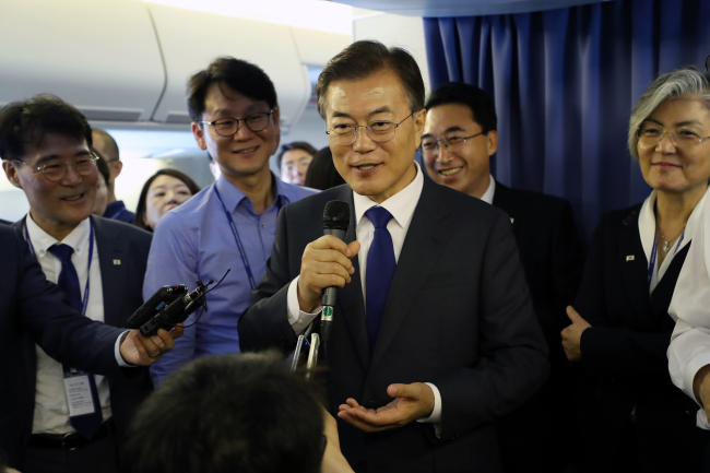 President Moon Jae-in addresses the media aboard the flight to Washington DC on Wednesday. Yonhap
