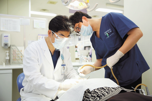 오는 7월 1일 ‘틀니의 날’을 맞아 노관태 경희대치과병원 보철과 교수(대한치과보철학회 이사)는 “치아가 전부 또는 거의 상실됐을 때에는 자신의 상태에 맞는 틀니가 권장된다”고 했다. 전문의가 틀니 시술에 앞서 미리 환자의 구강을 살펴보고 있다.   [사진제공=경희대치과병원]