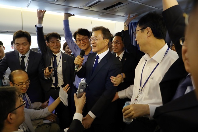 President Moon Jae-in talks with reporters aboard the presidential plane on his way to the United States for a four-day visit on June 28, 2017. (Yonhap)