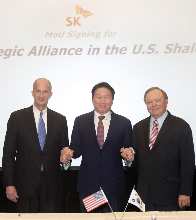 SK Group Chairman Chey Tae-won (center) holds hands