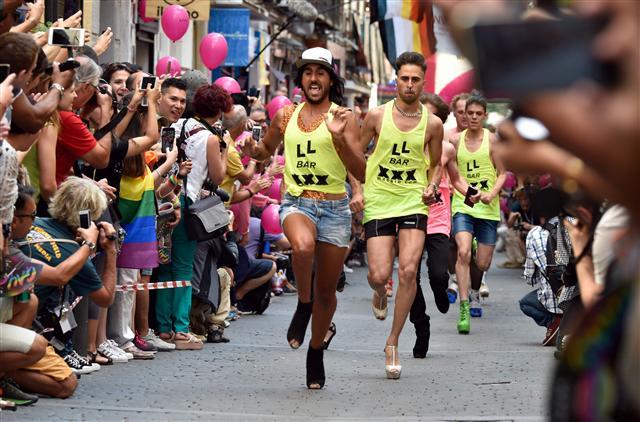 <YONHAP PHOTO-0244> Participants run during the "High Heels Race" as part of the WorldPride 2017 celebrations in Madrid on June 29, 2017. The annual festive race in Madrid gathers a crowd to witness participants running in at least 15 cm high heels. Madrid city hall predicts over two million people will take part in the WorldPride 2017 festivities, one of the biggest celebrations of lesbian, gay, bisexual and transgender rights, which will wrap up on July 2, 2017. / AFP PHOTO / GERARD JULIEN/2017-06-30 01:25:22/ <저작권자 ⓒ 1980-2017 ㈜연합뉴스. 무단 전재 재배포 금지.>