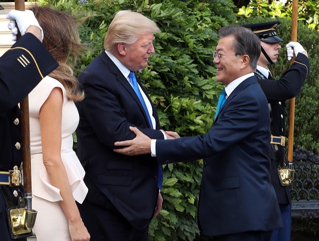 South Korean President Moon Jae-in (right) shakes hands with US President Donald Trump as he and his wife, Kim Jung-sook, arrived at the White House on June 29, 2017, for a dinner hosted by Trump and his wife, Melania, on the eve of the first Korea-US summit under the countries' new administrations. (Yonhap)