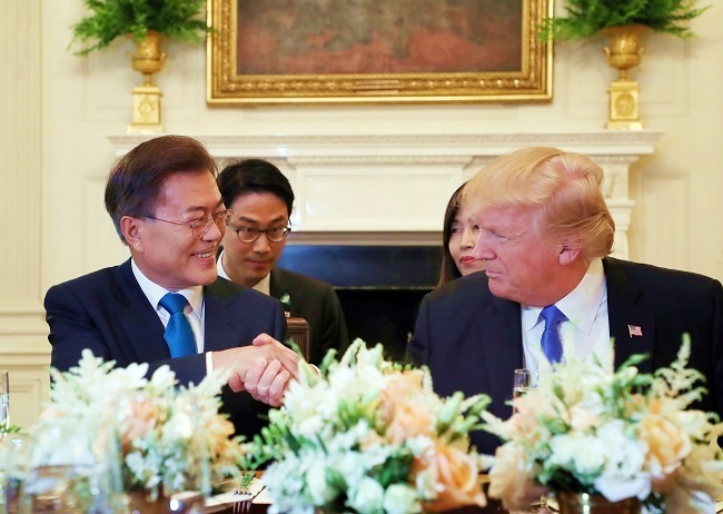 President Moon Jae-in (left) shakes hands with US President Donald Trump at a dinner at the White House in Washington, D.C. on June 29, 2017. (Yonhap)