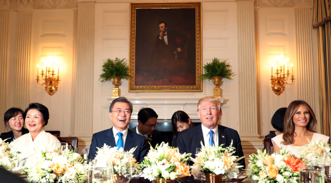 President Donald Trump with first lady Melania Trump (right), welcome South Korean President Moon Jae-in and his wife Kim Jung-sook (left), during a dinner in the State Dining Room of the White House in Washington, Thursday. (Yonhap)