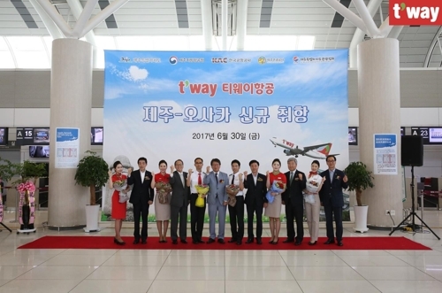 The company's CEO Jeong Hong-geun (6th from left) and employees celebrate the opening of the Jeju Island-Osaka route at Jeju International Airport on June 30, 2017. (T'way Air)