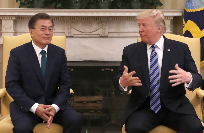 US President Donald Trump (right) speaks at a summit with President Moon Jae-in during their summit at the White House in Washington on Friday. (Yonhap)