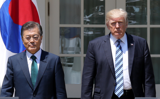 South Korean President Moon Jae-in (left) and US counterpart Donald Trump on Friday step in for their joint press briefing at the White House, following their summit discussion. (Yonhap)