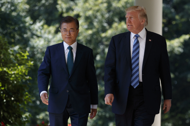 Presidents Moon Jae-in (left) and Donald Trump walk to make statements after their summit at the White House in Washington on Friday. (AP-Yonhap)