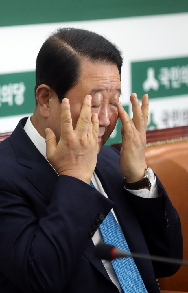 　People’s Party leader Rep. Park Joo-sun touches his face as he prepares for a press conference on Sunday about the scandal that involves his party member making a false accusation against the son of President Moon Jae-in during the presidential race in May. Yonhap