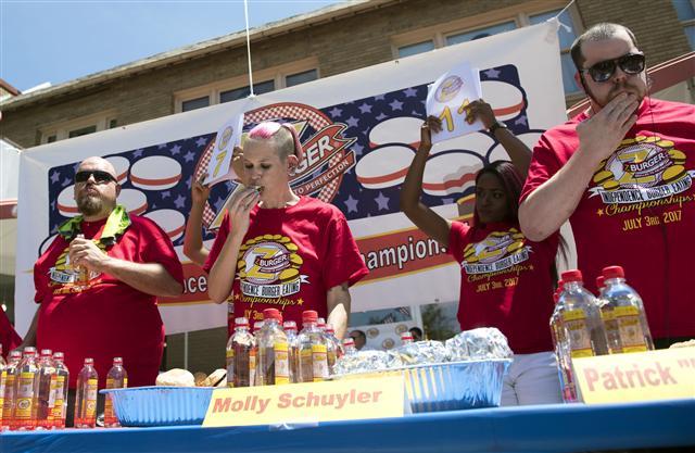 <YONHAP PHOTO-0538> Molly Schuyler (C), Patrick "Deep Dish" Bettletti (R) and Bob "Notorious B.O.B. Schoudt compete in the Z-Burger 8th Annual Independence Burger Eating Championship, in Washington D.C. on July 3, 2017. Schuyler won this year's contest eating 21 burgers in 10 minutes. Photo by Kevin Dietsch/UPI/2017-07-04 04:35:30/ <저작권자 ⓒ 1980-2017 ㈜연합뉴스. 무단 전재 재배포 금지.>
