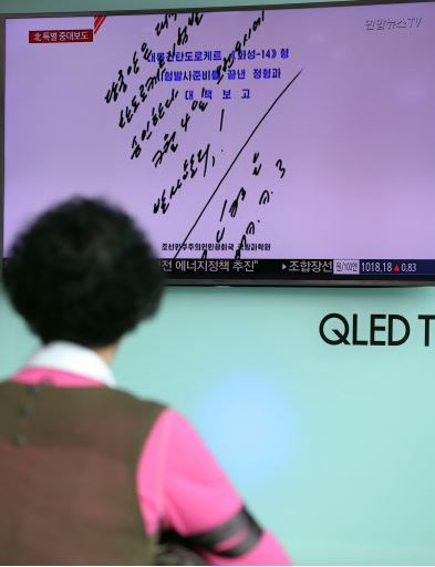 People watch a live TV report at Seoul Station on July 4, 2017, showing North Korea's special announcement that it has successfully tested an intercontinental ballistic missile. (Yonhap)