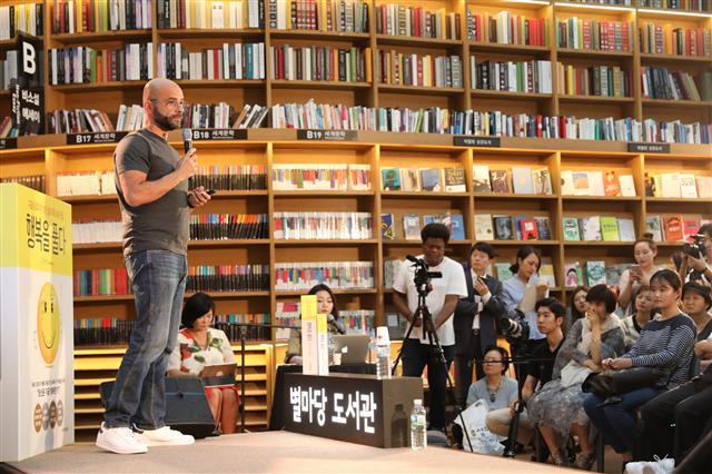 구글X의 모 가댓 부사장이 별마당도서관에서 대중을 상대로 강연하고 있다.