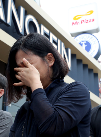 ‘갑질 논란’으로 피해를 호소하고 있는 미스터피자 가맹점주협의회 한 회원이 3일 오후 서울 서초구 미스터피자 본사가 있는 MP그룹 앞에서 열린 기자회견에서 갑질로 인한 피해의 보상과 근본적인 재발방지 대책 마련을 촉구하다 끝내 울음을 터뜨리고 있다. [사진제공=연합뉴스]