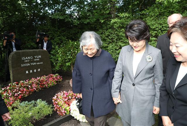 문재인 대통령 부인 김정숙 여사가 5일 오후(현지시간) 독일 베를린 가토우 공원묘지에 있는 윤이상 묘소를 찾아 참배한 뒤 윤이상 제자인 박영희 교수의 손을 잡고 있다. 	 [연합뉴스]