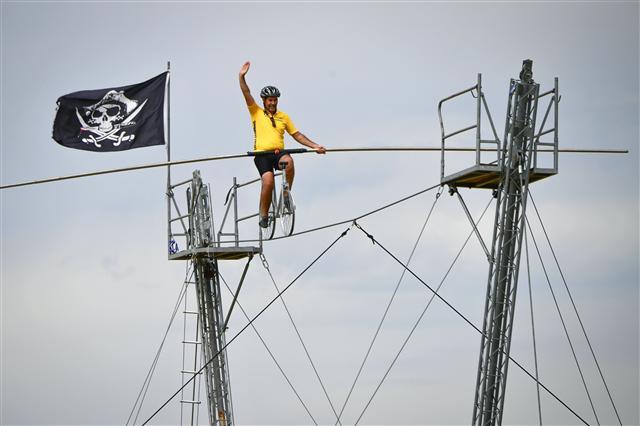 <YONHAP PHOTO-0440> A funambulist performs on a bike during the 216 km sixth stage of the 104th edition of the Tour de France cycling race on July 6, 2017 between Vesoul and Troyes. / AFP PHOTO / PHILIPPE LOPEZ/2017-07-07 02:14:44/ <저작권자 ⓒ 1980-2017 ㈜연합뉴스. 무단 전재 재배포 금지.>