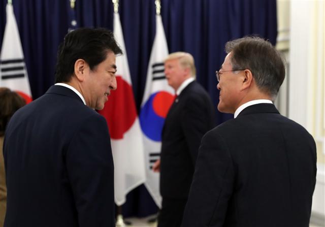 문재인 대통령과 아베 신조 일본 총리(왼쪽)가 6일 오후(현지시간) G20 정상회의가 열리는 독일 함부르크 시내 미국총영사관에서 열린 한미일 정상만찬에서 만나 얘기를 나누고 있다. 가운데는 도널드 트럼프 미국 대통령.   [연합뉴스]