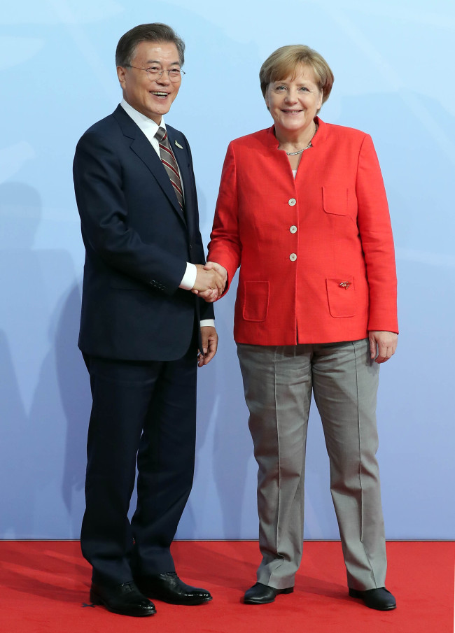 문재인 대통령이 7일 오전(현지 시각) 독일 함부르크 G20 정상회의장 메세홀에서 열린 공식환영식에 입장하며 주최국인 독일 앙겔라 메르켈 총리의 환영을 받고 있다. [제공=연합뉴스]