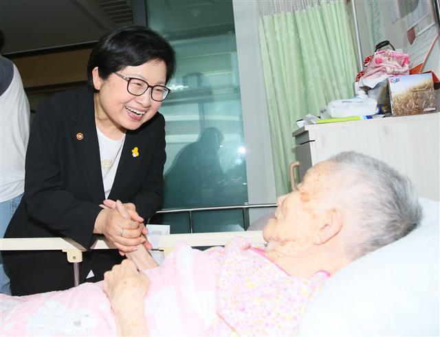 정현백 여성가족부 장관이 10일 오전 경기도 광주시 소재 나눔의 집을 방문해 병석에 누워있는 위안부 피해자 할머니의 손을 잡고 건강상태를 살피고 있다.  [사진제공=여성가족부]