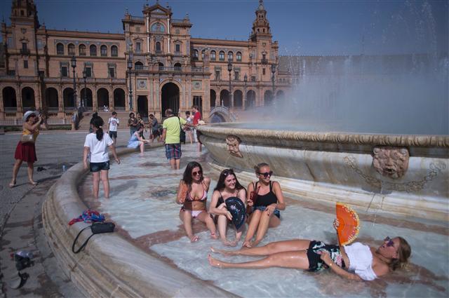 <YONHAP PHOTO-1124> Girls cool off in a fountain of the Plaza de Espana in Sevilla during a heat wave, on July 12, 2017. / AFP PHOTO / JORGE GUERRERO/2017-07-13 05:36:31/ <저작권자 ⓒ 1980-2017 ㈜연합뉴스. 무단 전재 재배포 금지.>