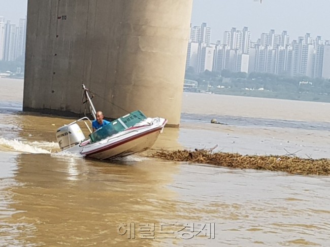 13일 최근 내린 호우로 상류에서 떠내려온 쓰레기를 치우기 위해 한강사업본부에서 모터보트를 이용해 쓰레기를 모으고 있다. [사진=이진용 기자/jycafe@heraldcorp.com]
