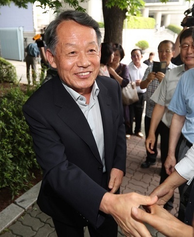 Retired Adm. Choi Yoon-hee, former chairman of the Joint Chiefs of Staff, with a smiling face, shakes hands with his acquaintances after he was acquitted by an appeals court of bribery charges in connection with a military chopper lobbying scandal, in Seoul on July 13, 2017. (Yonhap)