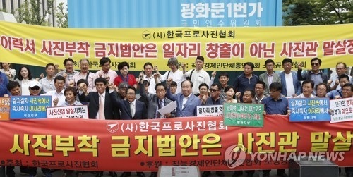 Photo studio owners hold a rally in Seoul on July 13, 2017, to protest the government's move to ban resume photos in the public sector. (Yonhap)