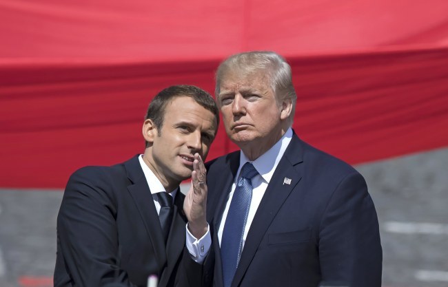 French President Emmanuel Macron (left) talks to US President Donald Trump while attending the traditional military parade as part of the Bastille Day celebrations in Paris on Friday. (EPA-Yonhap)