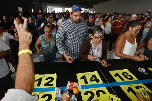 <YONHAP PHOTO-1390> Venezuelan citizens line up to vote in a non-binding referendum against the Venezuelan governement's plans to re-write their constitution to stay in power in Miami, Florida, on July 16, 2017. In Miami, Madrid and elsewhere Venezuelans living abroad enthusiastically cast ballots in a vote organized by the opposition that sought to undermine unpopular President Nicolas Maduro. / AFP PHOTO / RHONA WISE/2017-07-17 08:35:58/ <저작권자 ⓒ 1980-2017 ㈜연합뉴스. 무단 전재 재배포 금지.>