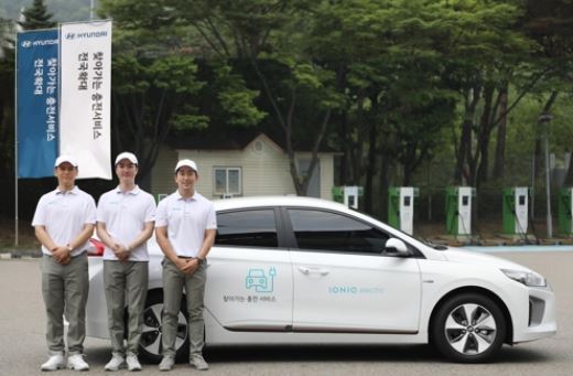 In this photo taken on July 17, 2017, Hyundai Motor employees stand before the carmaker's charging service vehicle in Seoul. (Courtesy of Hyundai Motor) (Yonhap)