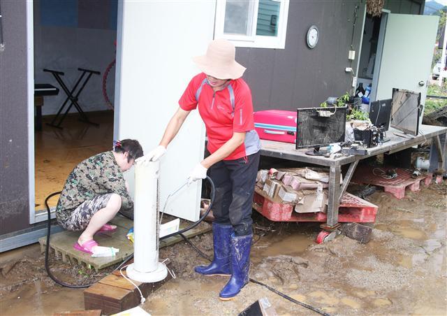 지난 주말 내린 집중호우로 아수라장이 된 충북 괴산군 청천면 후평리의 한 펜션에서 주민 등이 복구작업을 하고 있다. 괴산군 15~16일 누적 강수량은 198㎜였다.  [연합뉴스]