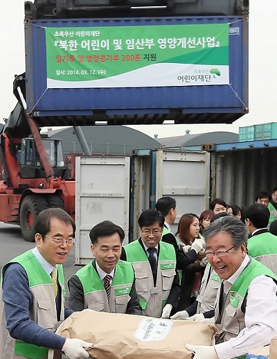 This undated file photo shows South Korean civic activists loading flour bags into a container for shipment to North Korea. (Yonhap)