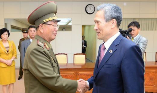 This file photo dated Aug. 25, 2015, shows South Korean National Security Adviser Kim Kwan-jin (R) and Hwang Pyong-so, the North Korean military's top political officer, shaking hands after completing inter-Korean high-level talks at the truce village of Panmunjom inside the Demilitarized Zone. On July 17, 2017, South Korea proposed to North Korea that inter-Korean military talks be held July 21 on reducing tensions along the border, a follow-up to President Moon Jae-in's recent peace overture made in his speech in Berlin. (Yonhap)
