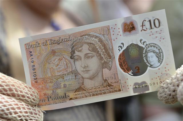 <YONHAP PHOTO-0128> People in period costume display the new ?10 note featuring Jane Austen, which marks the 200th anniversary of Austen's death, during the unveiling at Winchester Cathedral, England, Tuesday, July 18, 2017. At the unveiling Tuesday of the new ‘tenner’ at Winchester Cathedral in southern England, Bank of England Governor Mark Carney said the new note celebrates the “universal appeal” of Austen’s work. (Chris J Ratcliffe/PA via AP)/2017-07-19 00:57:51/ <저작권자 ⓒ 1980-2017 ㈜연합뉴스. 무단 전재 재배포 금지.>