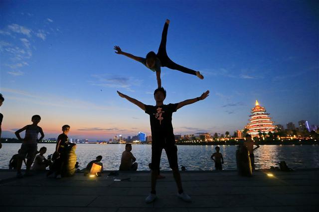 <YONHAP PHOTO-2099> Members of the Sichuan Province Acrobatic Troupe practice outdoors in the evening to avoid the summer heat, in Suining, in China's southwest Sichuan province on July 17, 2017. The folk art troupe, established 43 years ago, has performed in France, Japan, Singapore, Hong Kong and other countries and regions. / AFP PHOTO / STR / China OUT/2017-07-19 13:30:01/ <저작권자 ⓒ 1980-2017 ㈜연합뉴스. 무단 전재 재배포 금지.>