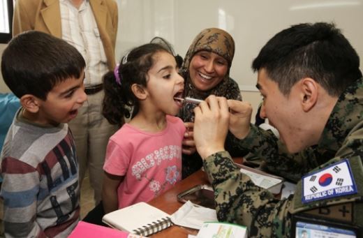 A Dongmyeong Unit soldier checks the teeth of a Lebanese kid in this undated file photo provided by South Korea's military. (Yonhap)
