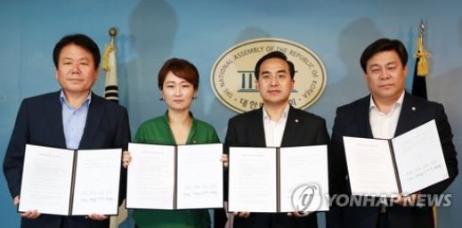 The vice floor leaders of the ruling and opposition parties hold the document detailing their agreement on a government reorganization bill during a press conference at the National Assembly in Seoul on July 20, 2017. (Yonhap)