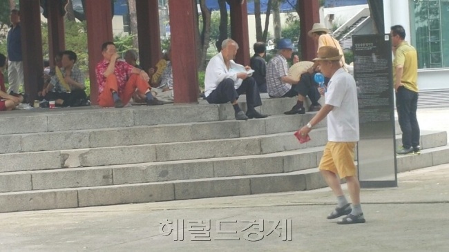 지난 21일 오후 서울 종로구 탑골공원에서 휴대용 미니선풍기를 이용하고 있는 80대 노인의 모습.