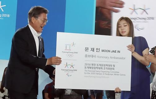 President Moon Jae-in (L) is presented with an enlarged version of his new business card listing him as an honorary ambassador for the PyeongChang Winter Olympic Games by former South Korean Olympic figure skating champion Kim Yu-na in an event held in PyeongChang, located some 180 kilometers east of Seoul, on July 24, 2017. (Yonhap)
