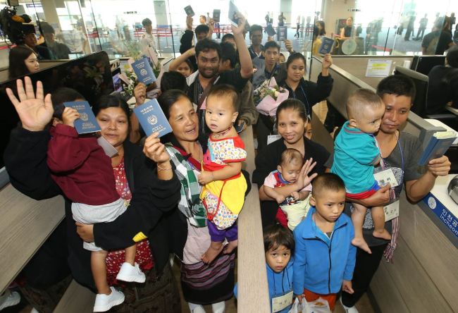 WELCOME -- A group of Myanmarese refugees wave upon arriving at Incheon Airport on Tuesday as part of a United Nations-led refugee resettlement program. South Korea decided to take in five families, totaling 30 people, in the final year of the three-year pilot project. (Yonhap)